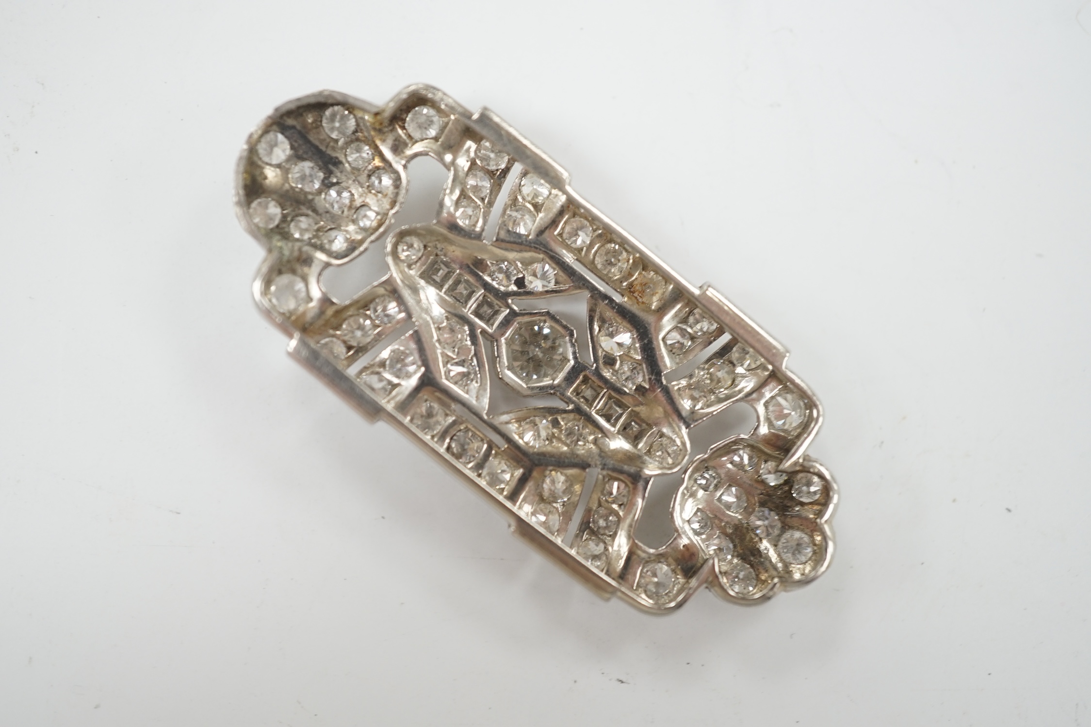 A white metal and diamond cluster set shaped rectangular brooch? (lacking fittings)